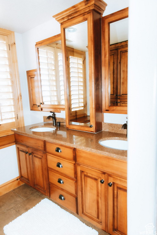 Bathroom featuring oversized vanity, a wealth of natural light, and double sink