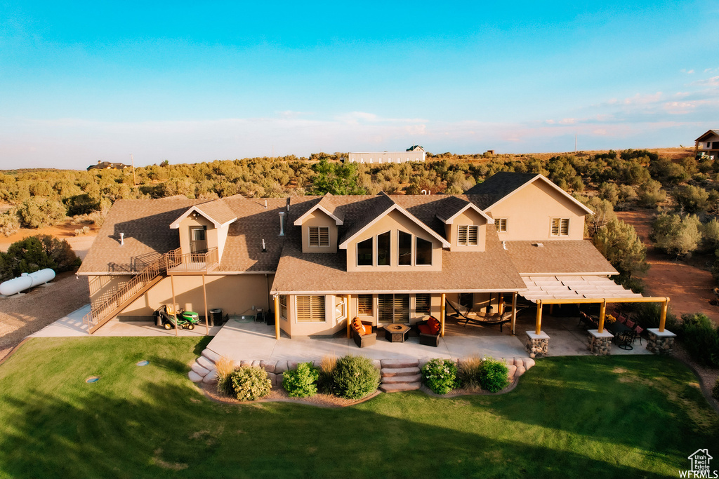 Rear view of property with a patio and a yard