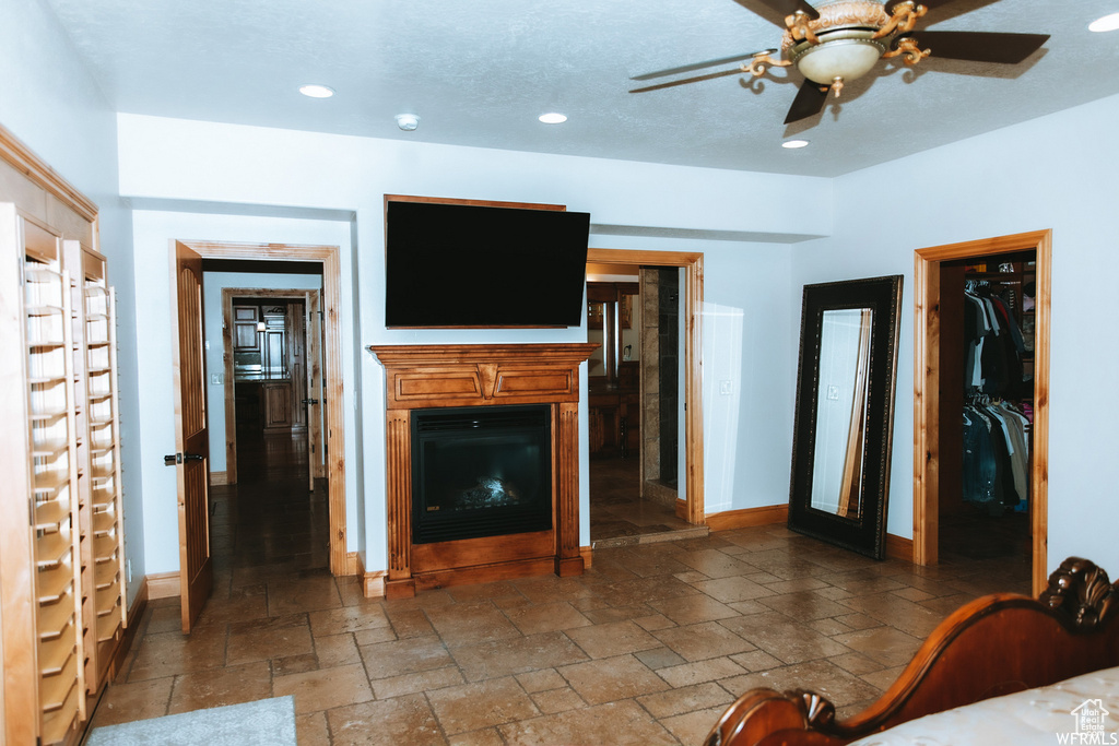 Unfurnished living room with dark tile flooring and ceiling fan