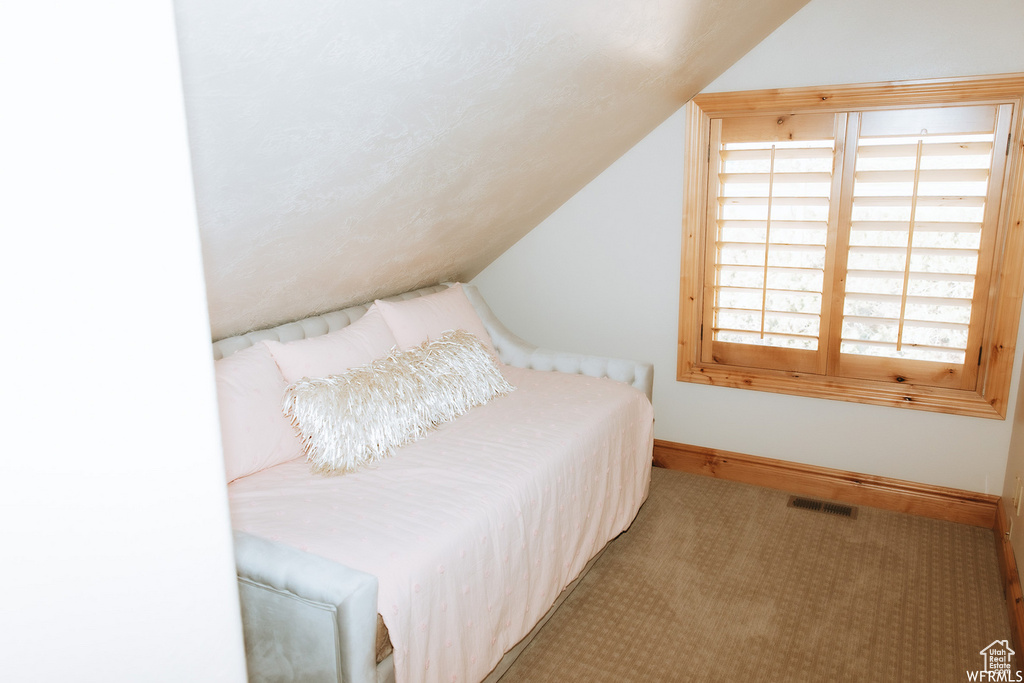 Bedroom featuring lofted ceiling and carpet floors