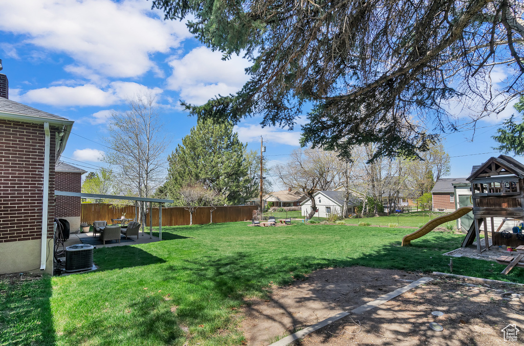 View of yard featuring a patio, a playground, an outdoor living space, and central AC unit