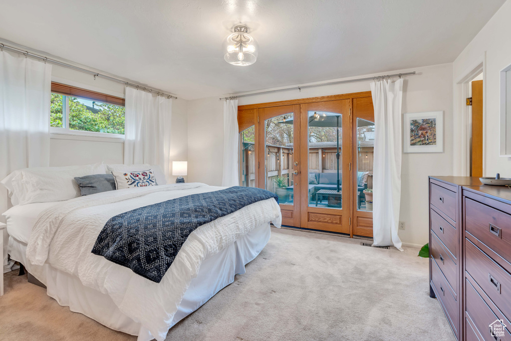Carpeted bedroom featuring french doors and access to exterior