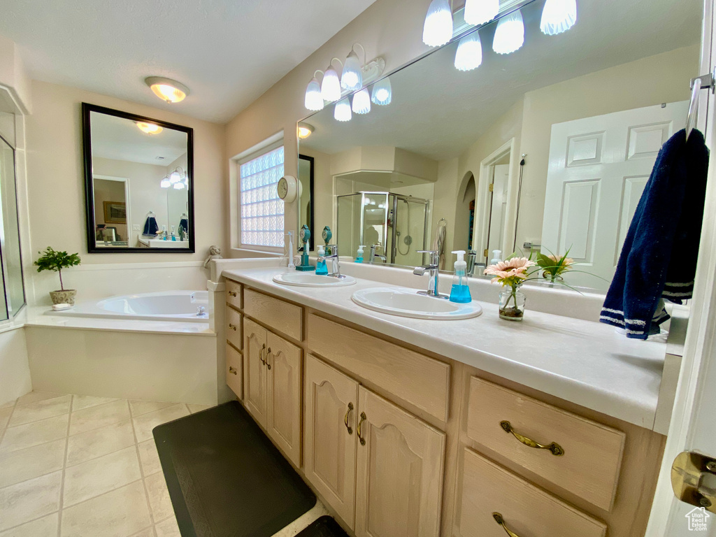 Bathroom featuring tile floors, independent shower and bath, and large vanity