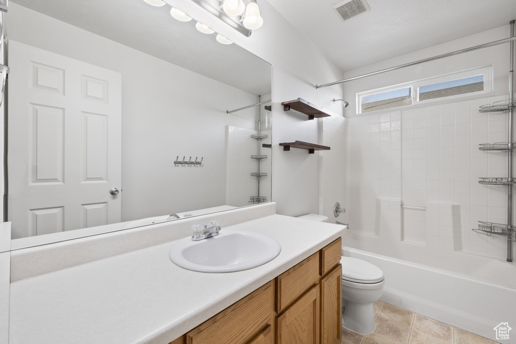 Full bathroom with  shower combination, tile floors, toilet, and vanity