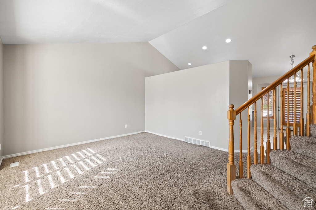 Unfurnished room featuring carpet floors and lofted ceiling