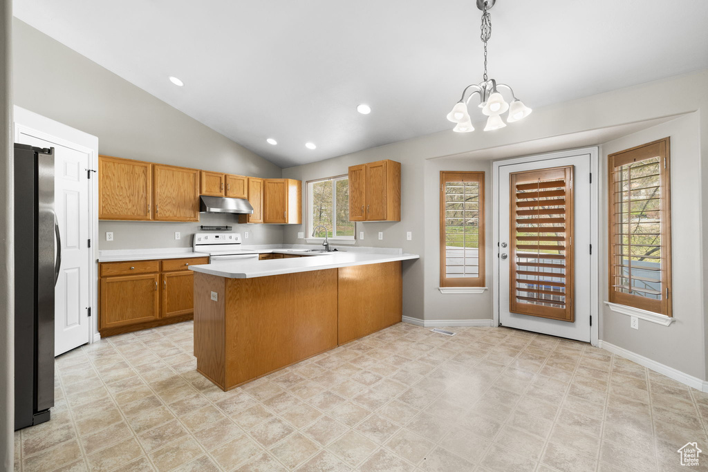 Kitchen featuring white electric stove, hanging light fixtures, light tile floors, and kitchen peninsula