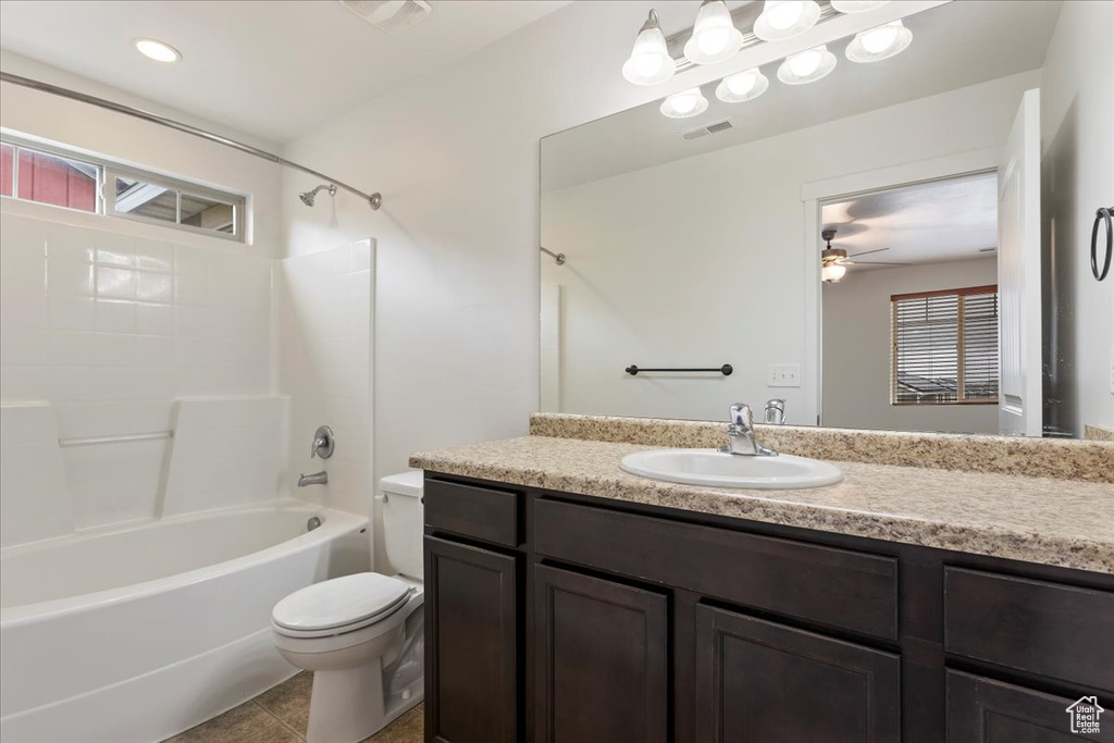 Full bathroom with tile floors, oversized vanity, tub / shower combination, toilet, and ceiling fan