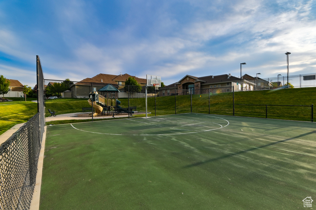 View of sport court featuring a lawn and a playground