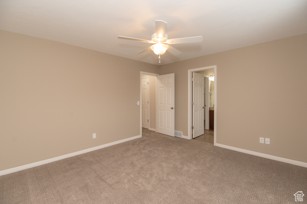 Unfurnished bedroom with ceiling fan and dark carpet