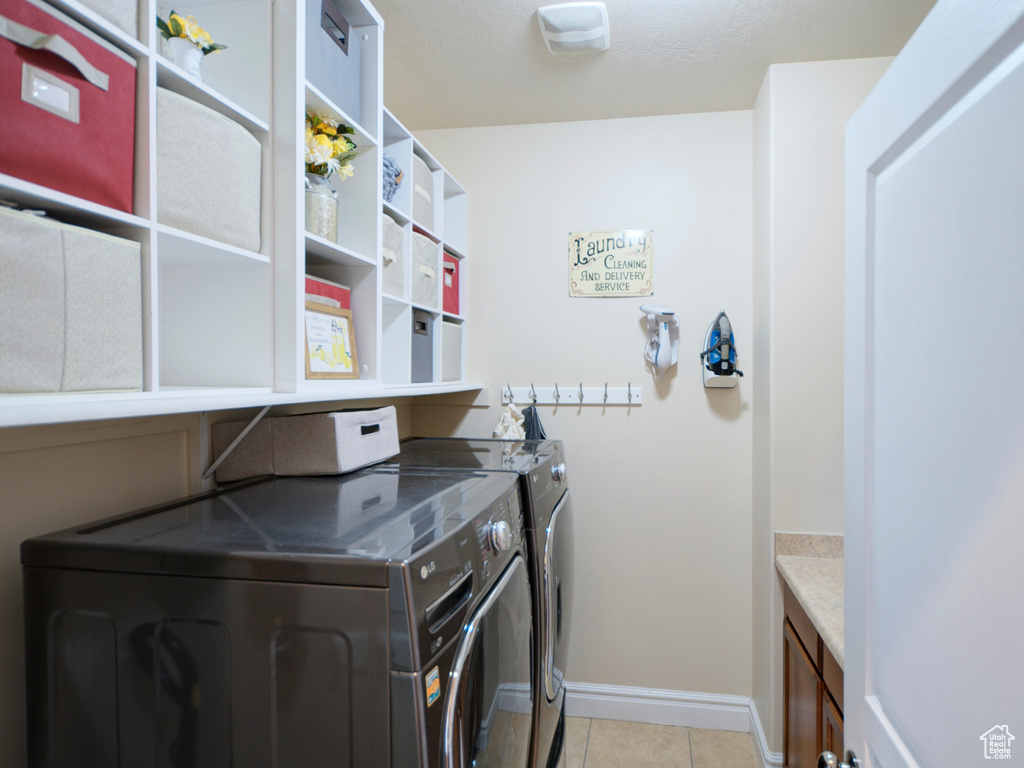 Laundry room with independent washer and dryer and light tile floors