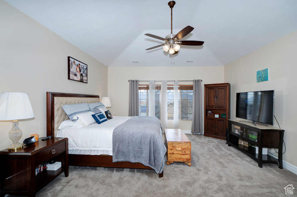 Carpeted bedroom with ceiling fan and vaulted ceiling