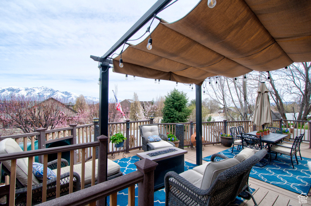 Wooden deck featuring a mountain view and a pergola