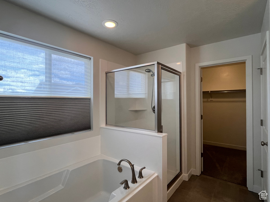 Bathroom with shower with separate bathtub and tile floors