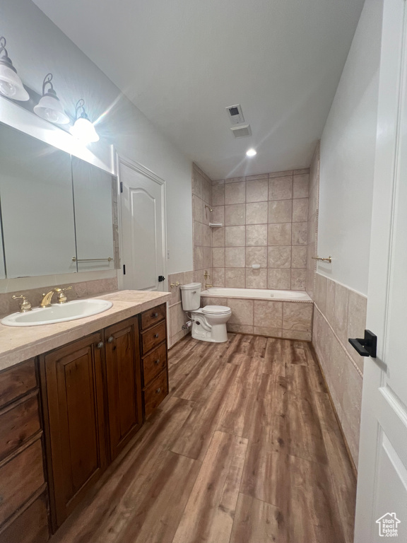 Bathroom with hardwood / wood-style floors, vanity, a bidet, and toilet