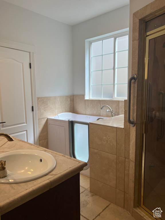 Bathroom featuring a shower with door, tile flooring, and vanity