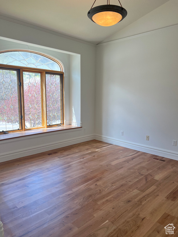 Unfurnished room with hardwood / wood-style floors and lofted ceiling