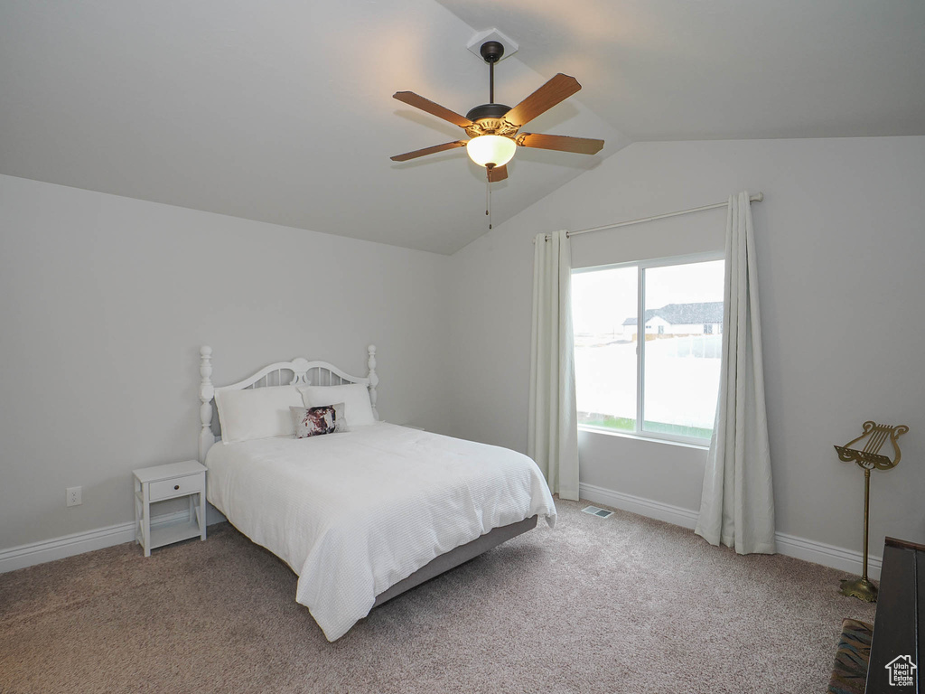 Bedroom with light carpet, vaulted ceiling, and ceiling fan