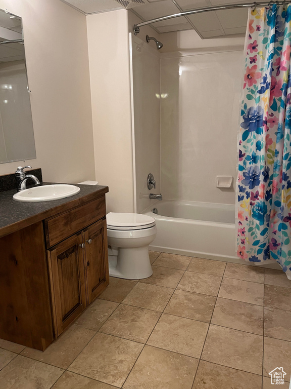 Full bathroom featuring tile flooring, vanity, toilet, and shower / tub combo with curtain
