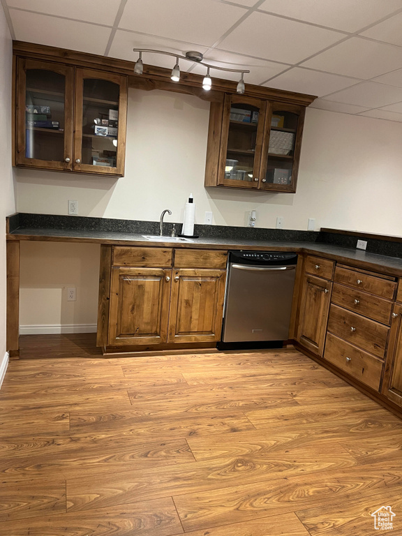 Kitchen with light hardwood / wood-style floors, dishwasher, rail lighting, sink, and a paneled ceiling