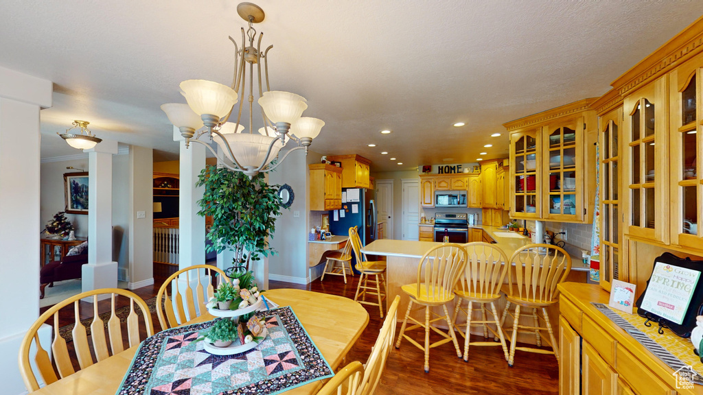 Dining space with hardwood / wood-style flooring, an inviting chandelier, crown molding, and sink