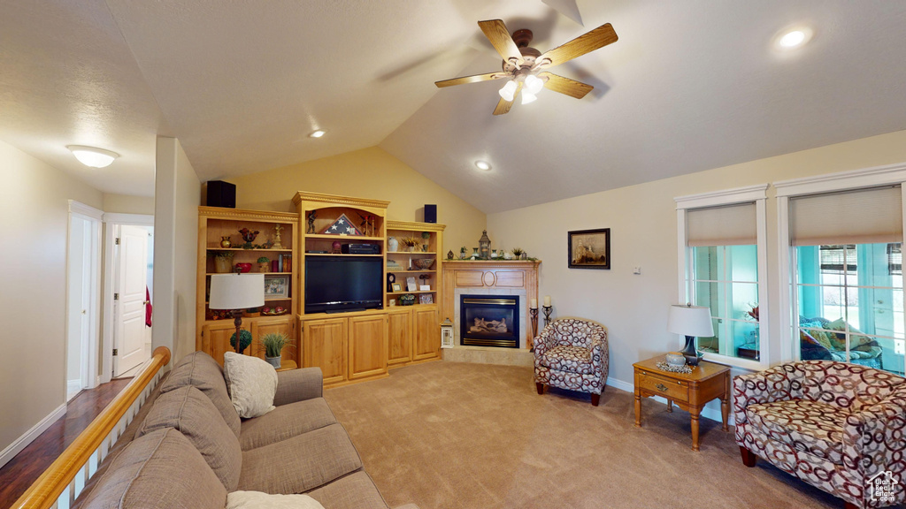 Living room with light hardwood / wood-style floors, ceiling fan, and lofted ceiling