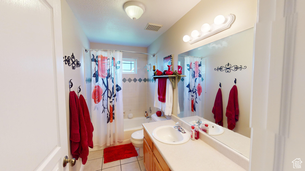 Full bathroom featuring oversized vanity, toilet, tile flooring, and shower / bath combo with shower curtain
