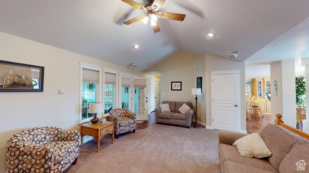 Carpeted living room with vaulted ceiling and ceiling fan