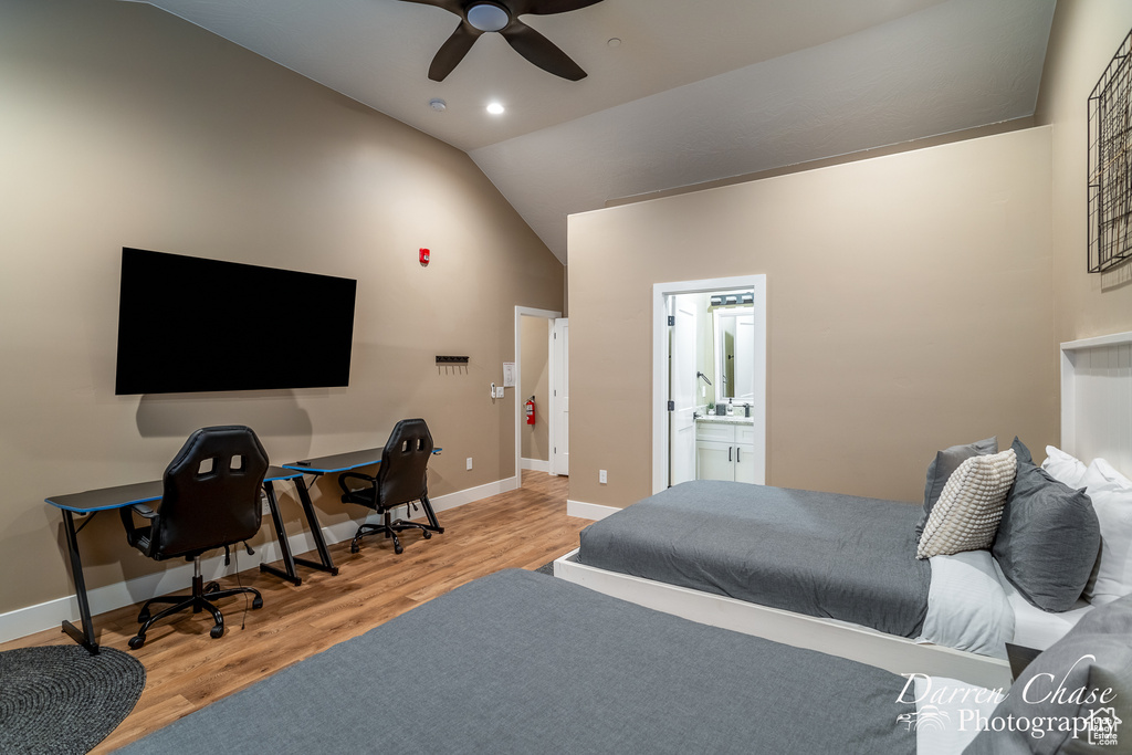 Bedroom featuring light hardwood / wood-style flooring, ceiling fan, vaulted ceiling, and ensuite bathroom