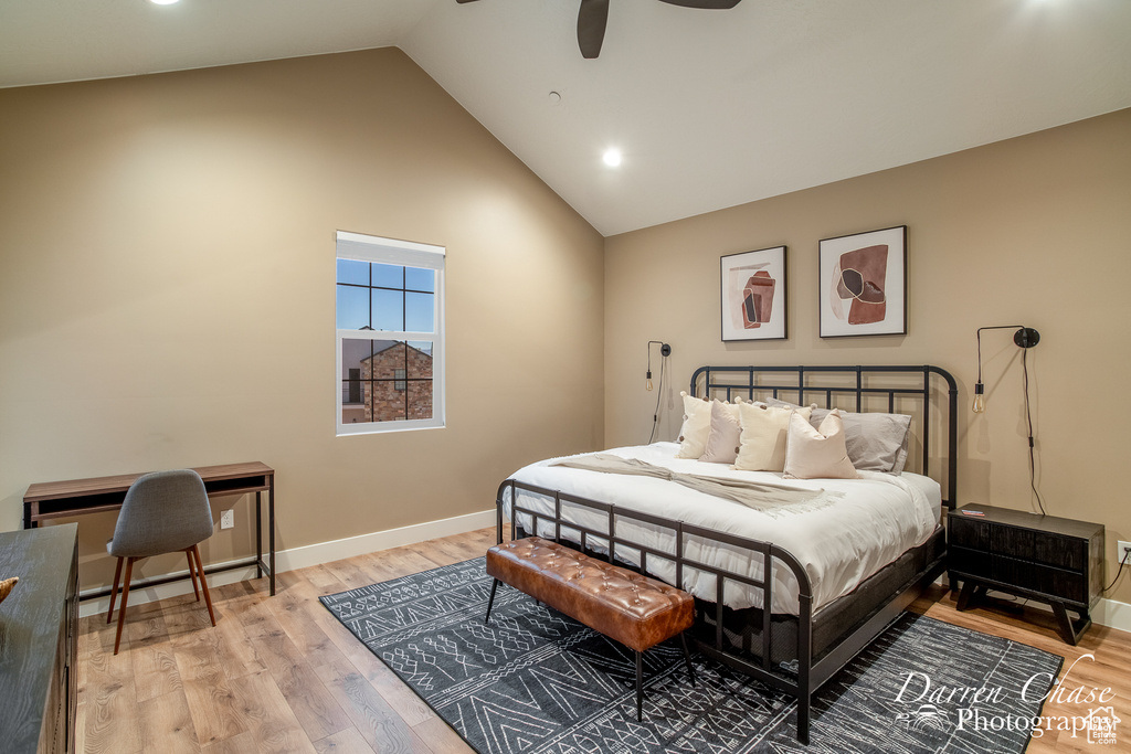 Bedroom with high vaulted ceiling, light hardwood / wood-style floors, and ceiling fan
