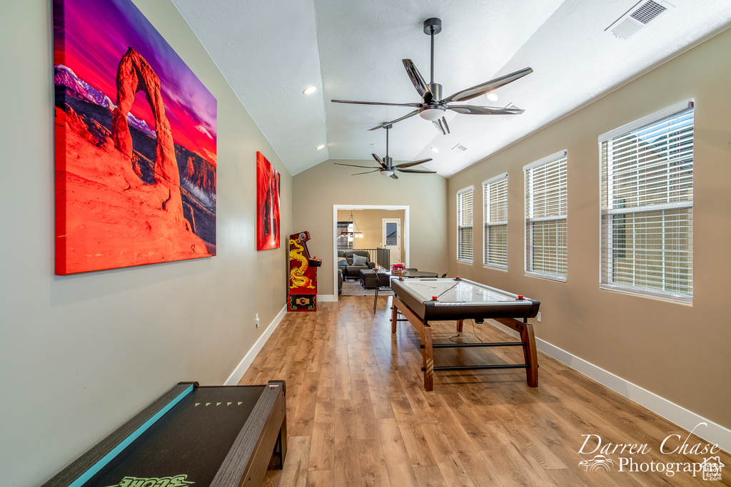 Recreation room featuring lofted ceiling, light hardwood / wood-style floors, and ceiling fan