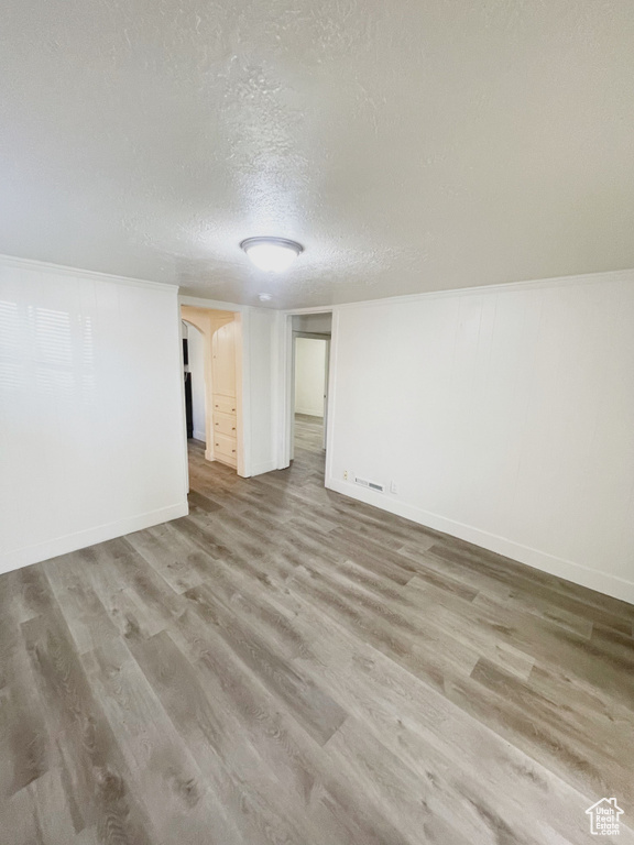 Spare room featuring hardwood / wood-style floors and a textured ceiling
