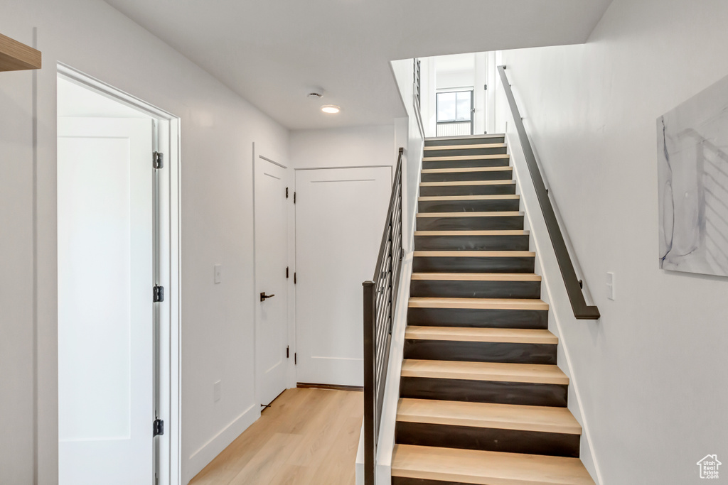 Stairs with light hardwood / wood-style flooring