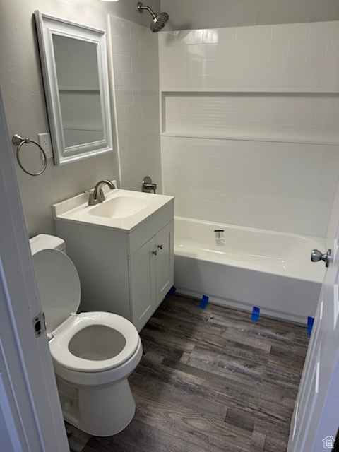 Full bathroom with toilet, vanity, bathing tub / shower combination, and hardwood / wood-style flooring