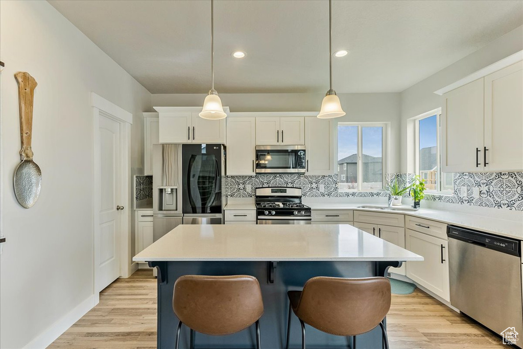 Kitchen featuring backsplash, pendant lighting, and stainless steel appliances