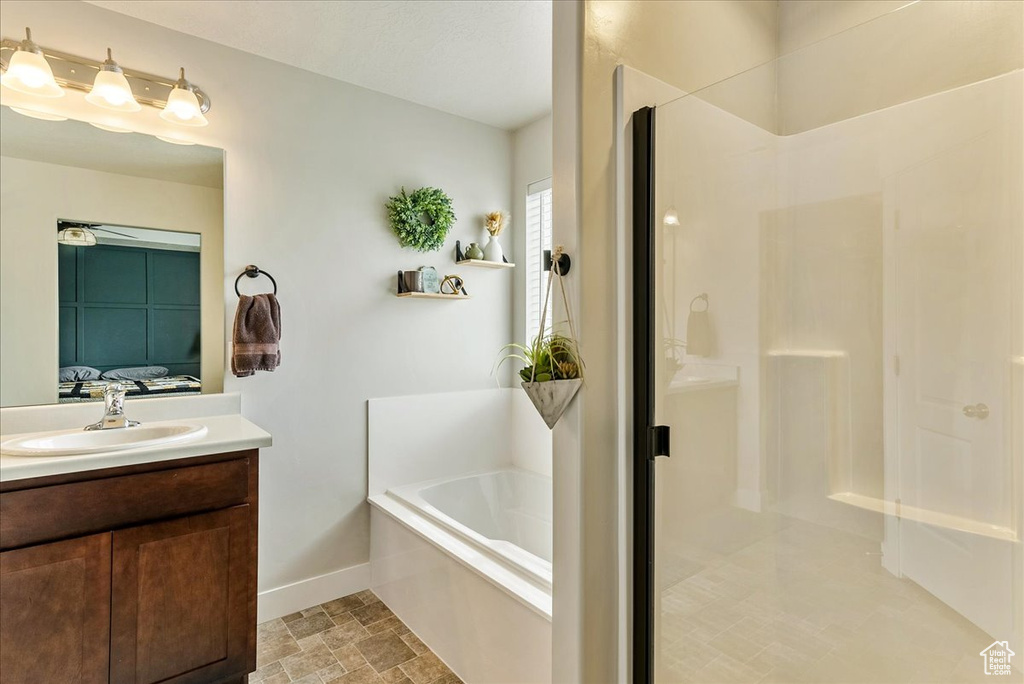 Bathroom with separate shower and tub, tile floors, and vanity