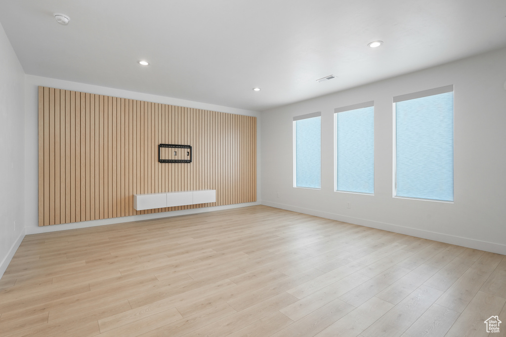 Unfurnished room featuring light hardwood / wood-style floors and radiator heating unit