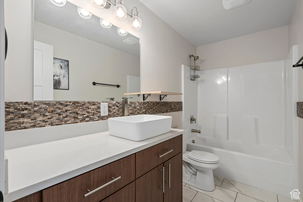 Full bathroom featuring vanity, toilet, shower / bathtub combination, and tile flooring