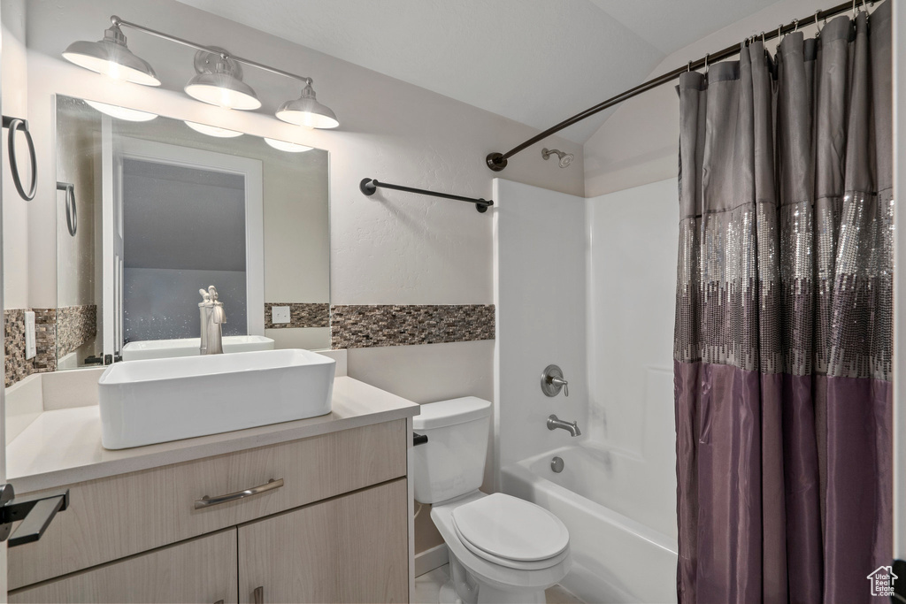 Full bathroom with shower / tub combo with curtain, vanity, and toilet