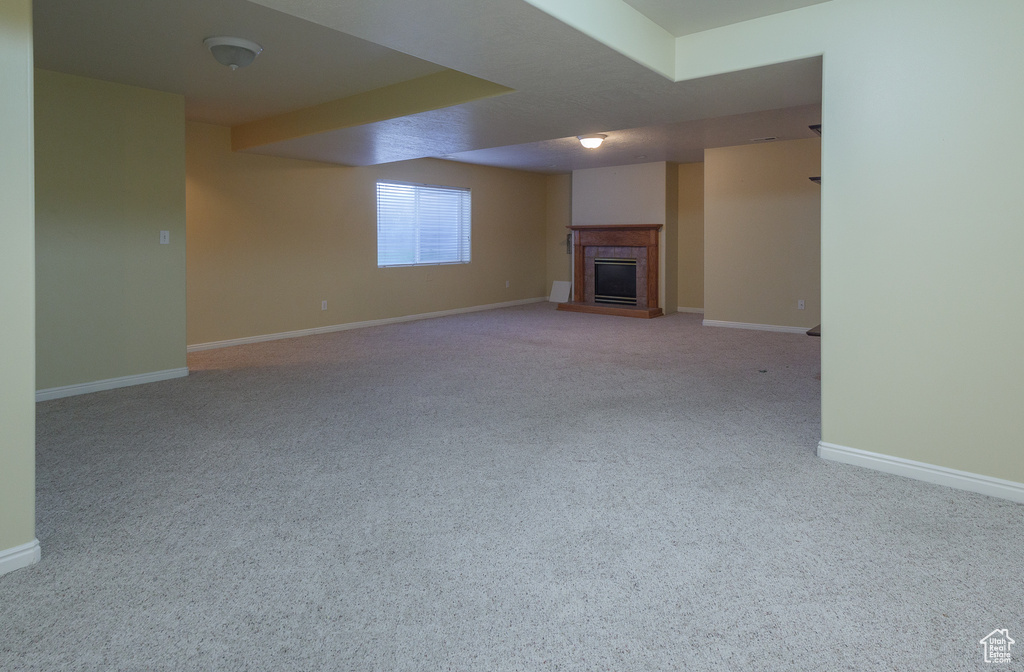 Unfurnished living room featuring light carpet