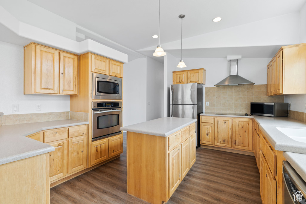 Kitchen featuring light brown cabinetry, appliances with stainless steel finishes, wall chimney range hood, and dark hardwood / wood-style floors