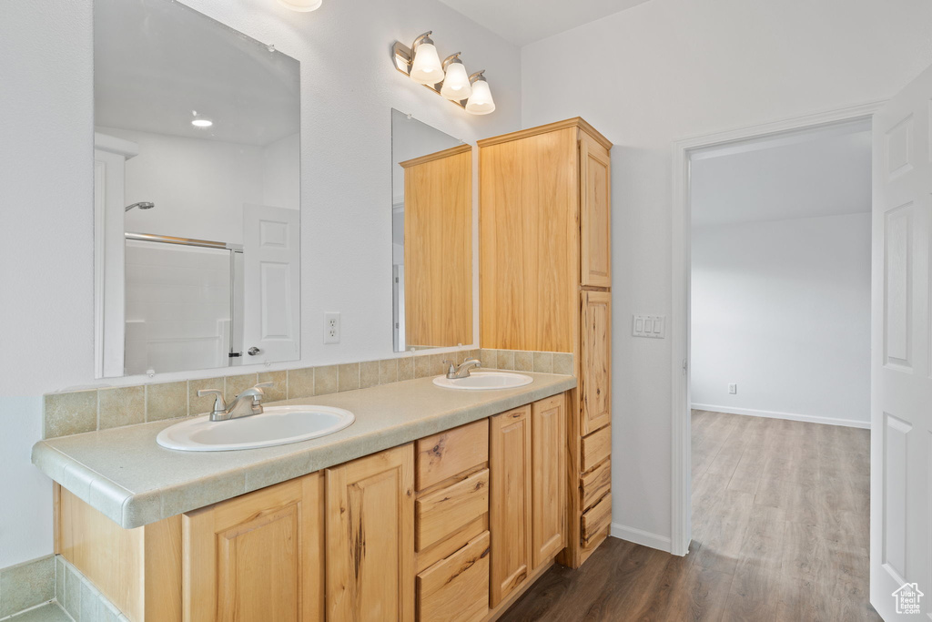 Bathroom with hardwood / wood-style floors, oversized vanity, and double sink