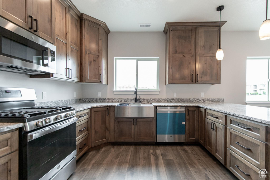 Kitchen with plenty of natural light, sink, stainless steel appliances, and dark wood-type flooring