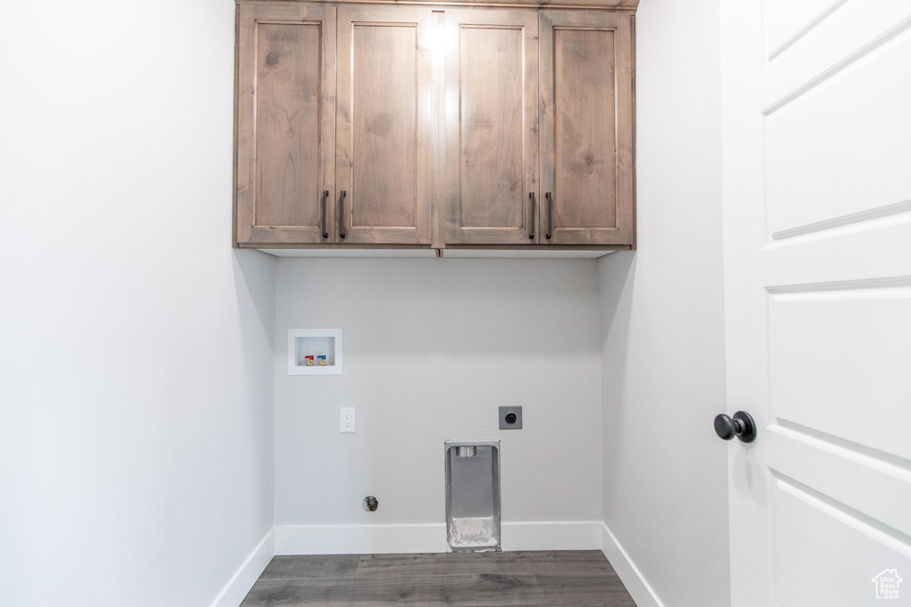 Clothes washing area featuring cabinets, hardwood / wood-style floors, hookup for an electric dryer, and hookup for a washing machine