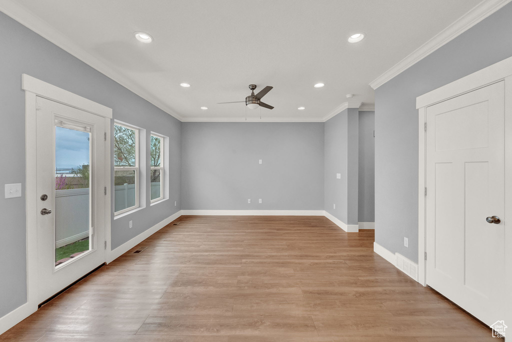 Spare room with ornamental molding, light hardwood / wood-style floors, and ceiling fan