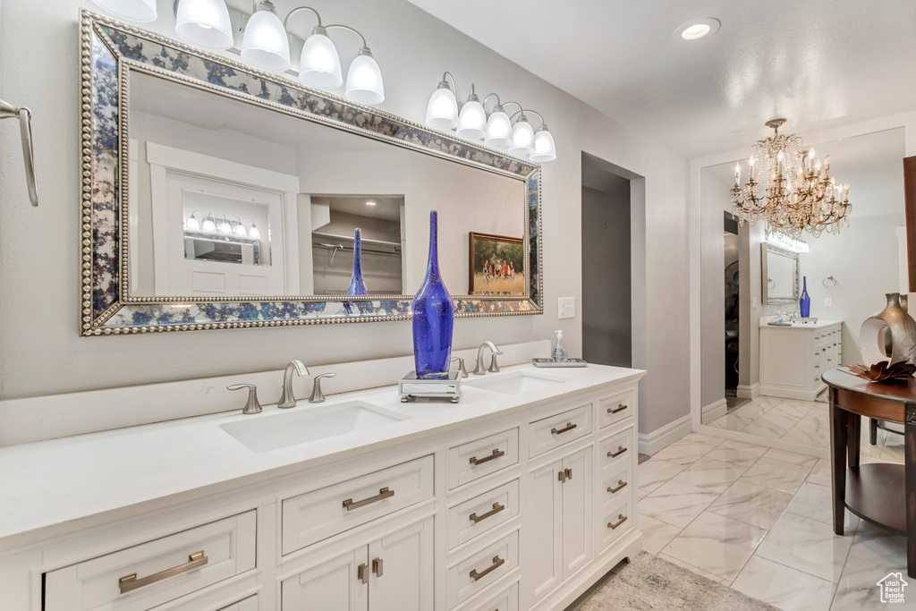 Bathroom featuring dual vanity, tile floors, and an inviting chandelier
