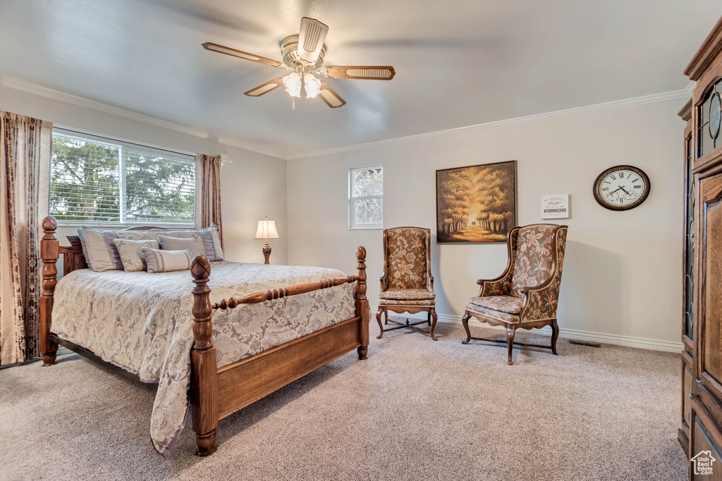 Bedroom with crown molding, light colored carpet, and ceiling fan