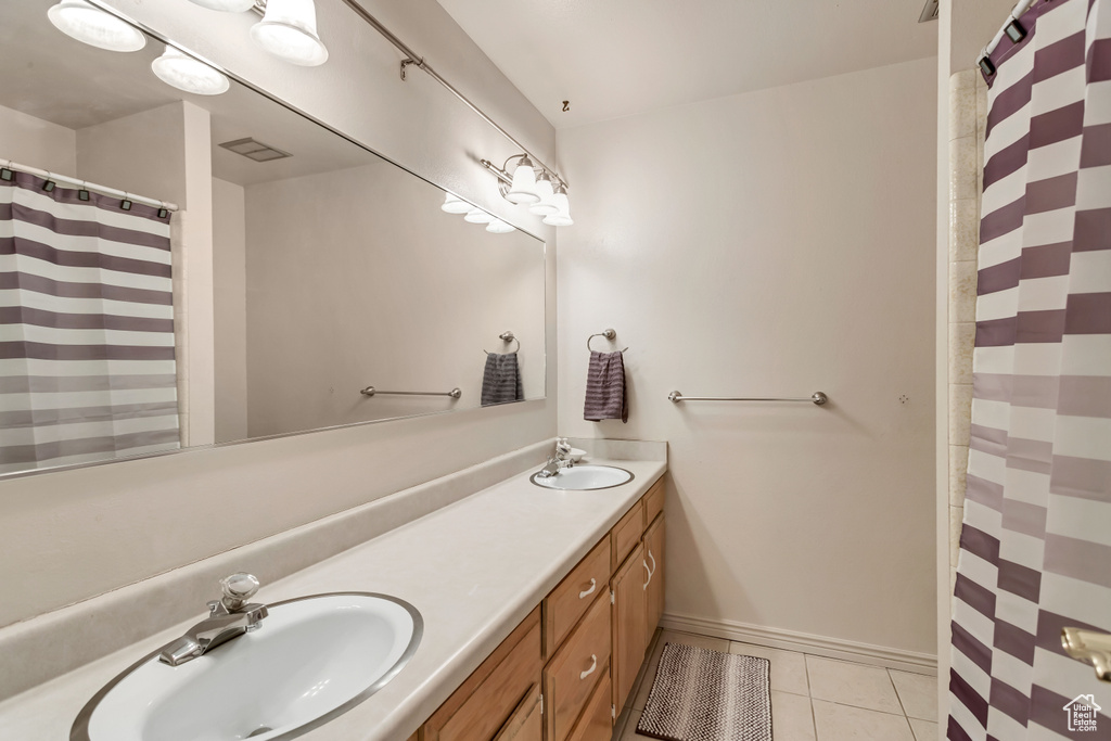 Bathroom featuring tile flooring, dual sinks, and oversized vanity