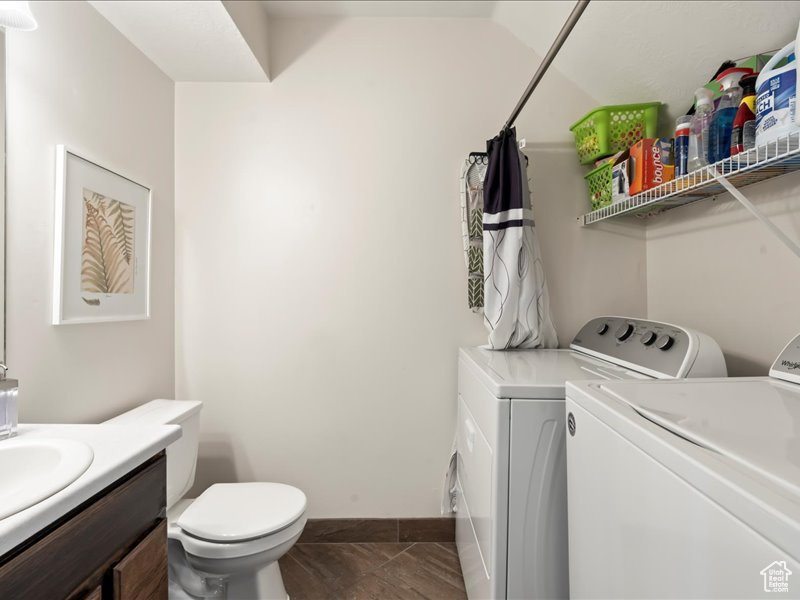 Laundry room featuring independent washer and dryer and dark tile floors