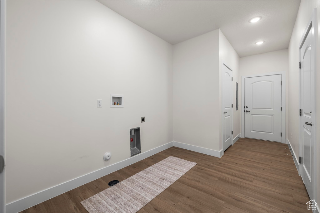 Laundry room with hookup for an electric dryer, hookup for a gas dryer, wood-type flooring, and washer hookup