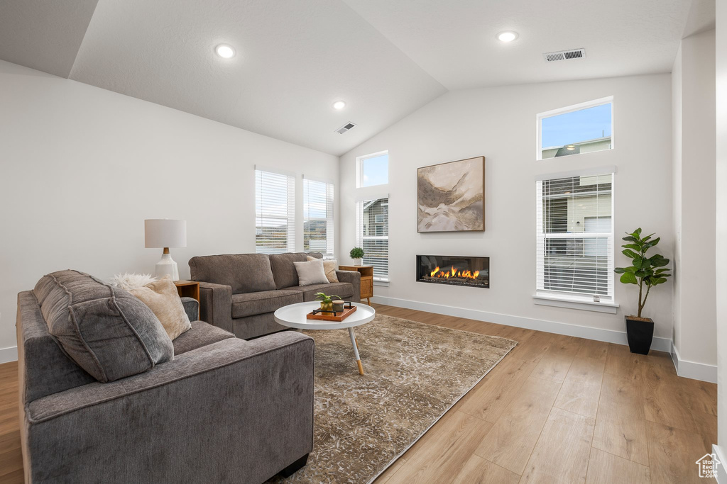 Living room featuring light hardwood / wood-style floors and high vaulted ceiling